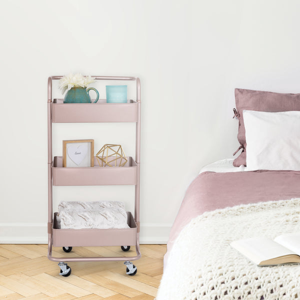 Rose gold cart next to bed