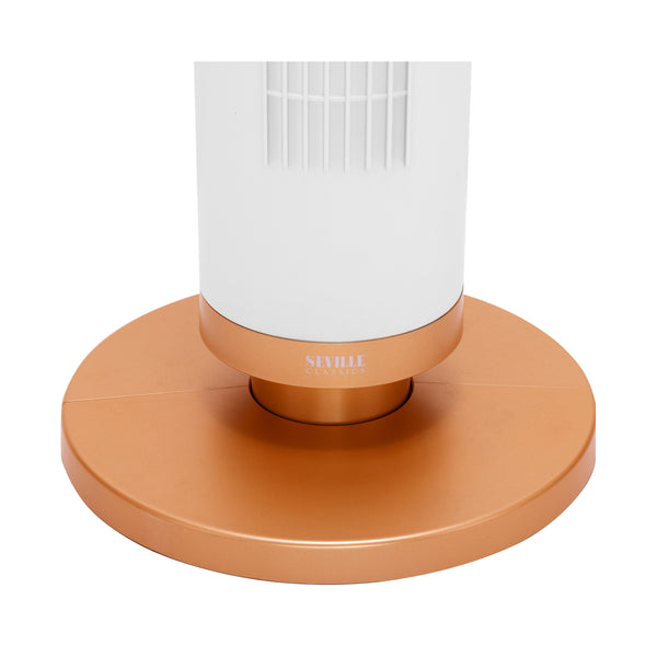 A modern tower fan with a white cylindrical body and a copper-colored circular base, shown on a plain white background. The brand name 'SEVILLE' is printed on the collar of the base.