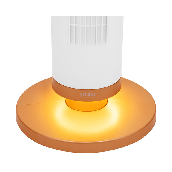 A close up featuring a glowing warm yellow-orange light from the bottom of a circular copper-colored base, with a white cylindrical body above it on a plain white background.