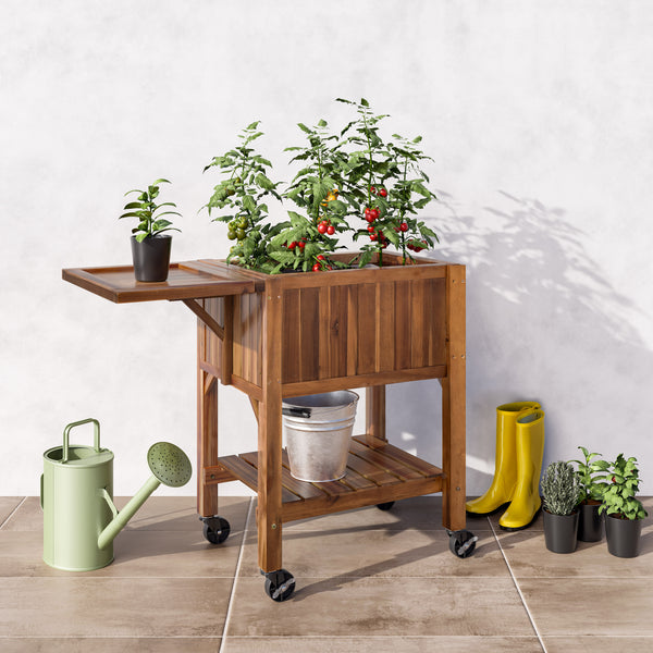 Acacia wood planter with plants, watering can, and boots on a tiled floor.