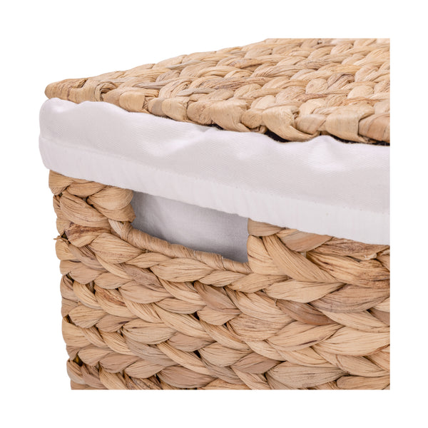 Close-up of a woven natural water hyacinth hamper with a white fabric liner visible along the edge, on a white background.